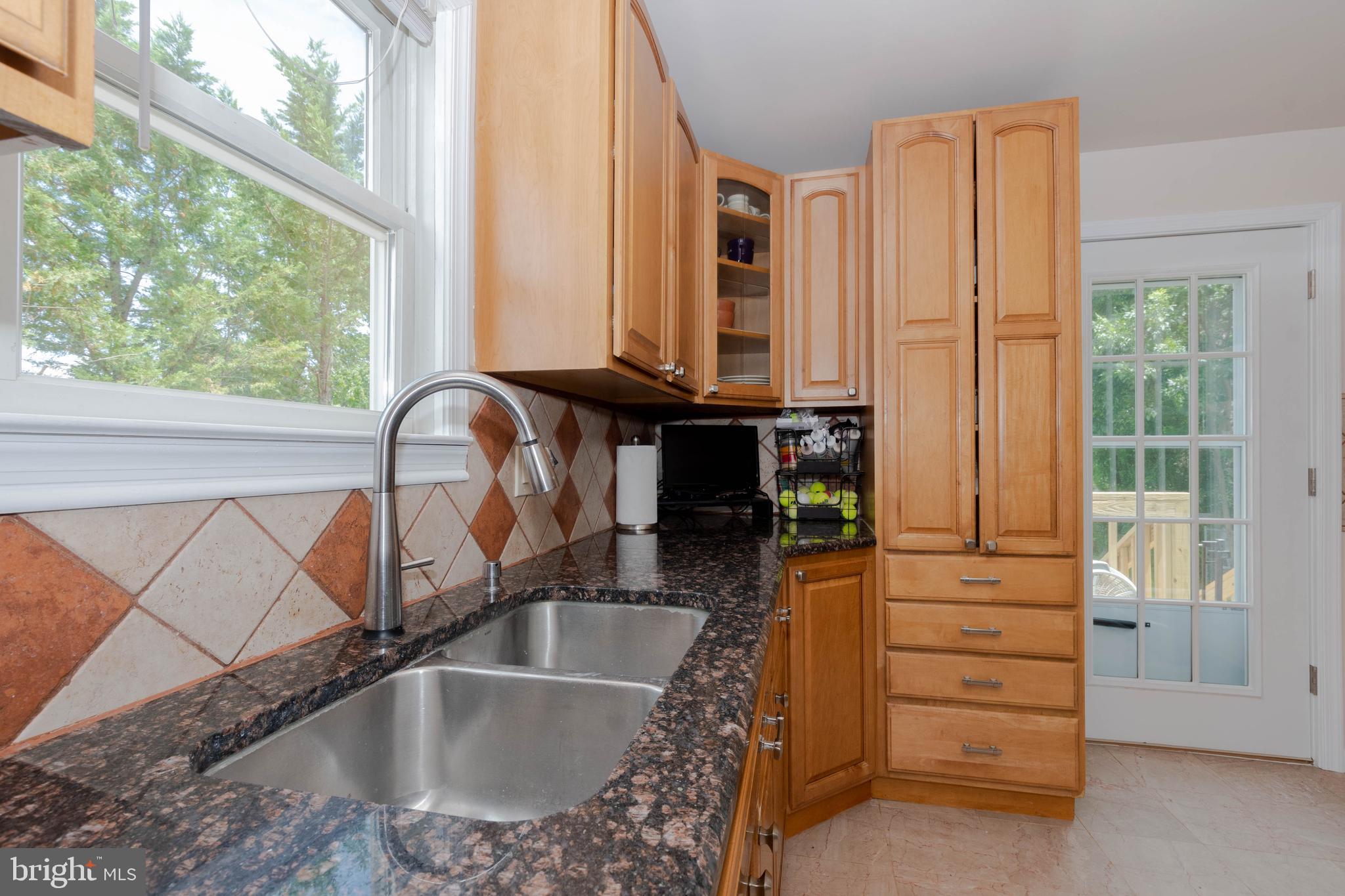 6414 Kenwood Avenue Rosedale, MD 21237 - Photo 19 of 60 a kitchen with a granite countertop sink and a window