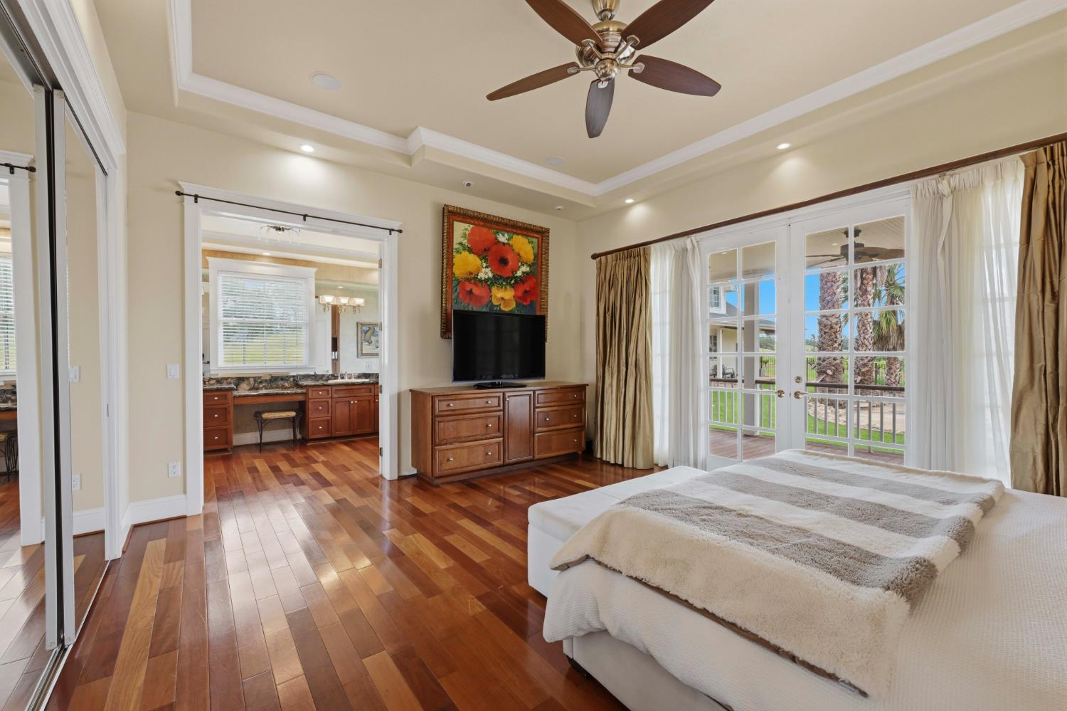 10120 Shenandoah Road Plymouth, CA 95669 - Photo 30 of 86 a bedroom with a large bed a flat tv screen and a chandelier