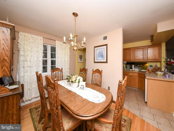 a view of a dining room with furniture a chandelier and wooden floor