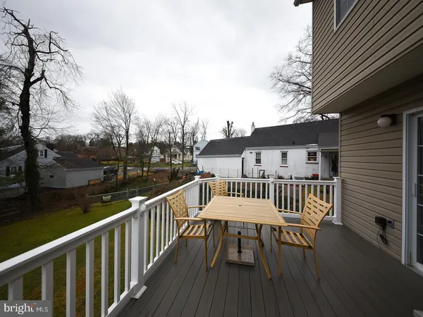 a view of a roof deck with table and chairs and wooden floor