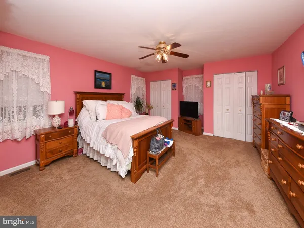 a bedroom with a bed dresser and a fireplace