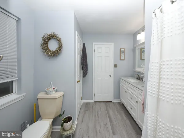 a bathroom with a granite countertop sink mirror vanity and toilet