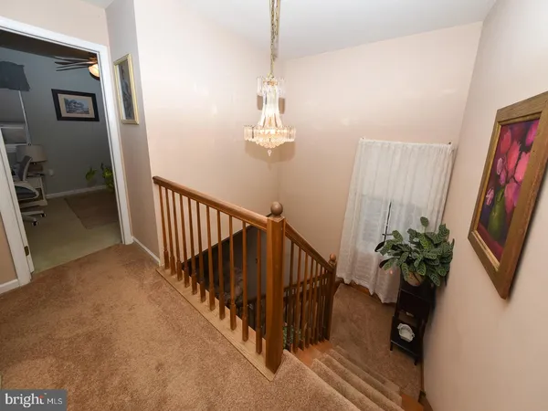 a view of a hallway with wooden floor and stairs