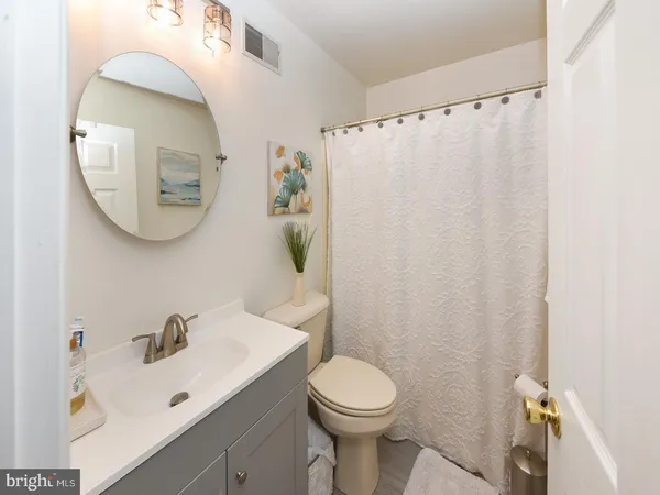 a bathroom with a sink a toilet and a mirror