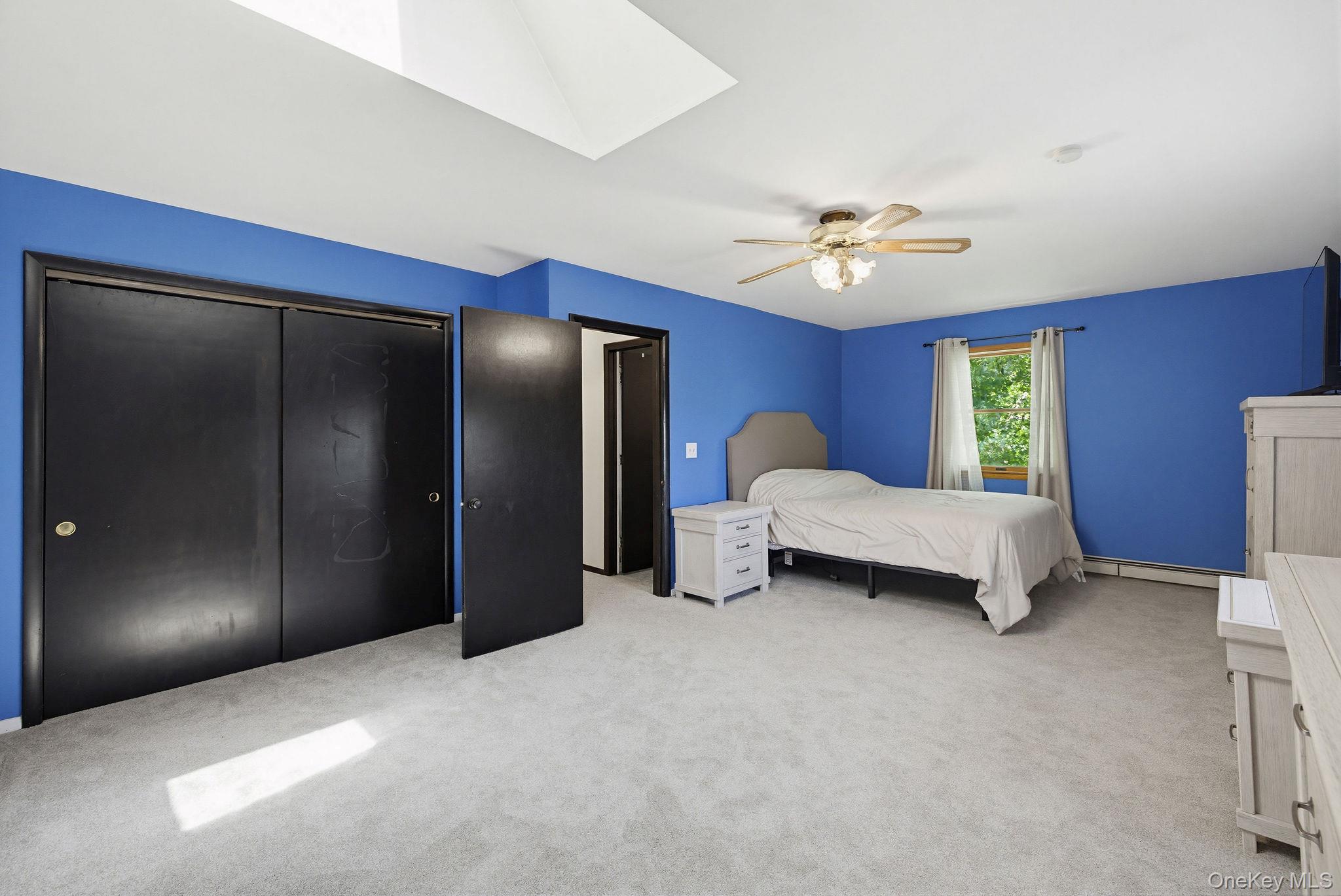 12 Bradhurst Road Carmel, NY 10512 - Photo 22 of 28 a bedroom with a bed and a chandelier