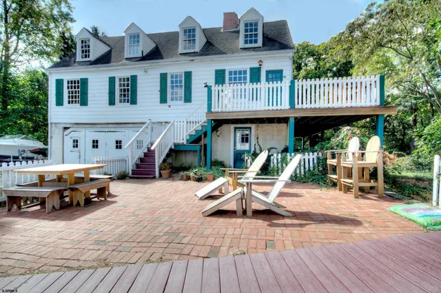 a front view of a house with patio outdoor dining space and trees