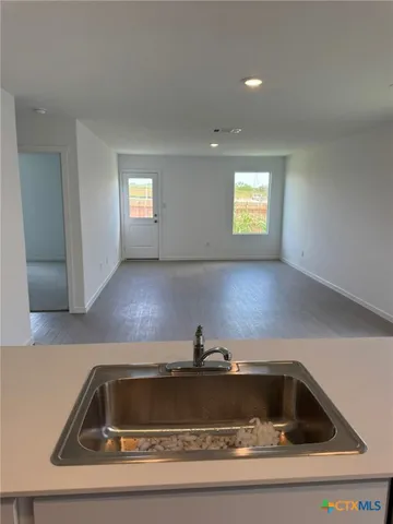 a view of a kitchen counter top a sink and dishwasher with wooden floor