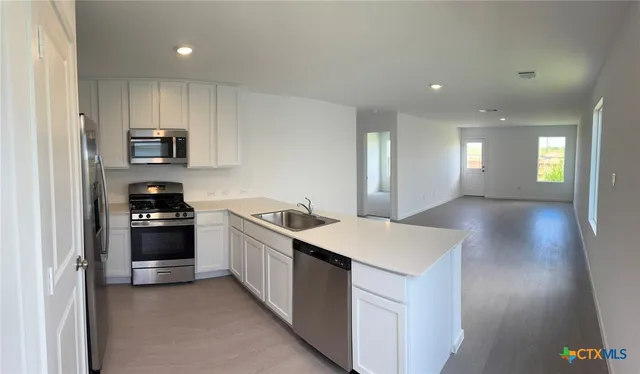 a kitchen with a sink and a stove top oven