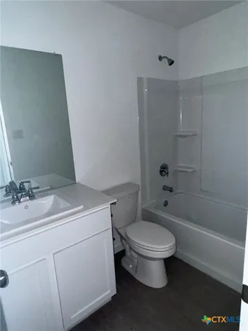 a bathroom with a granite countertop toilet a sink and a bathtub