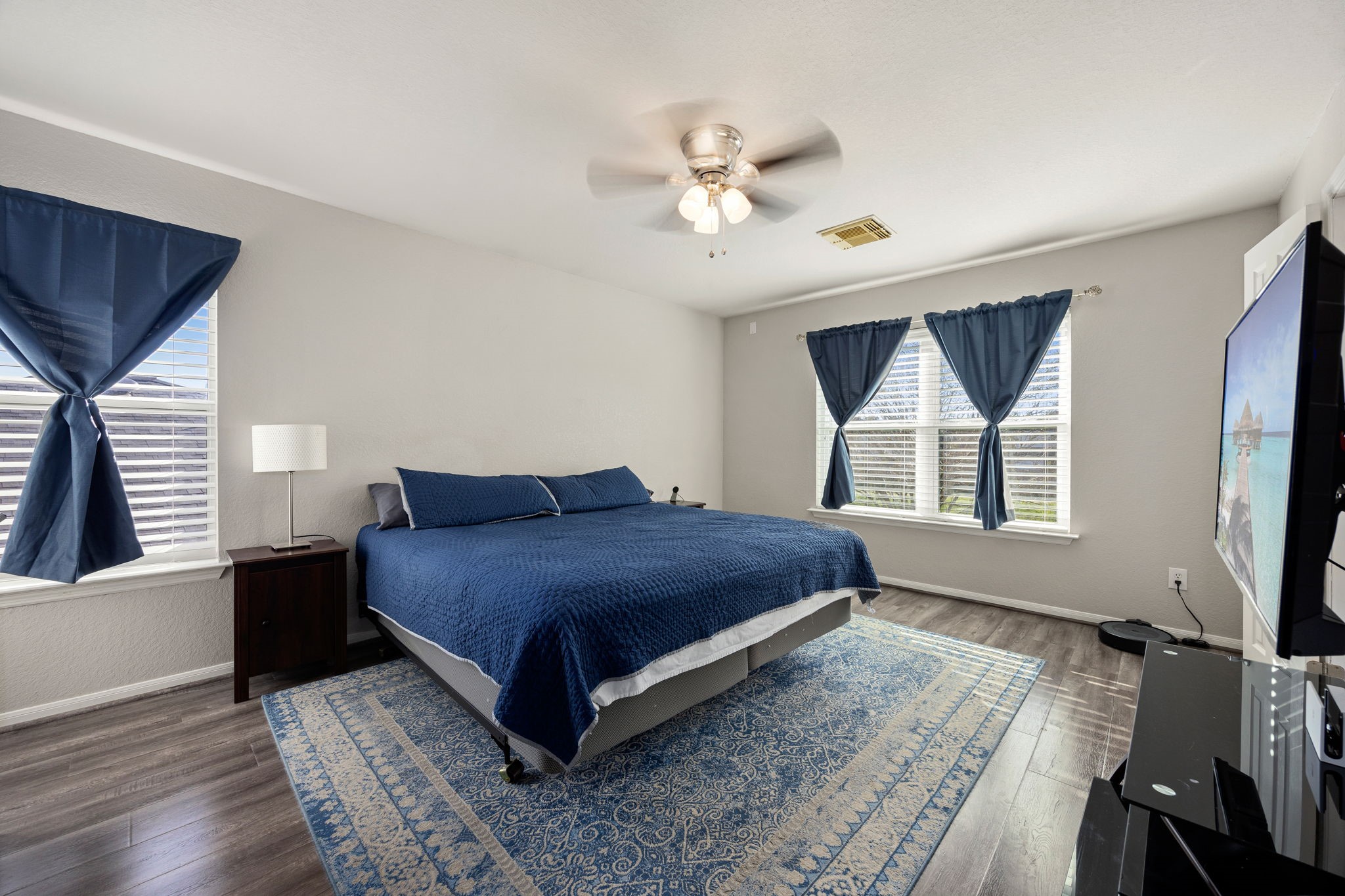 25515 Twister Trail Spring, TX 77373 - Photo 18 of 33 Spacious bedroom with large windows, plenty of natural light, and a ceiling fan. Features include Luxury vinyl flooring and a modern ceiling fan.