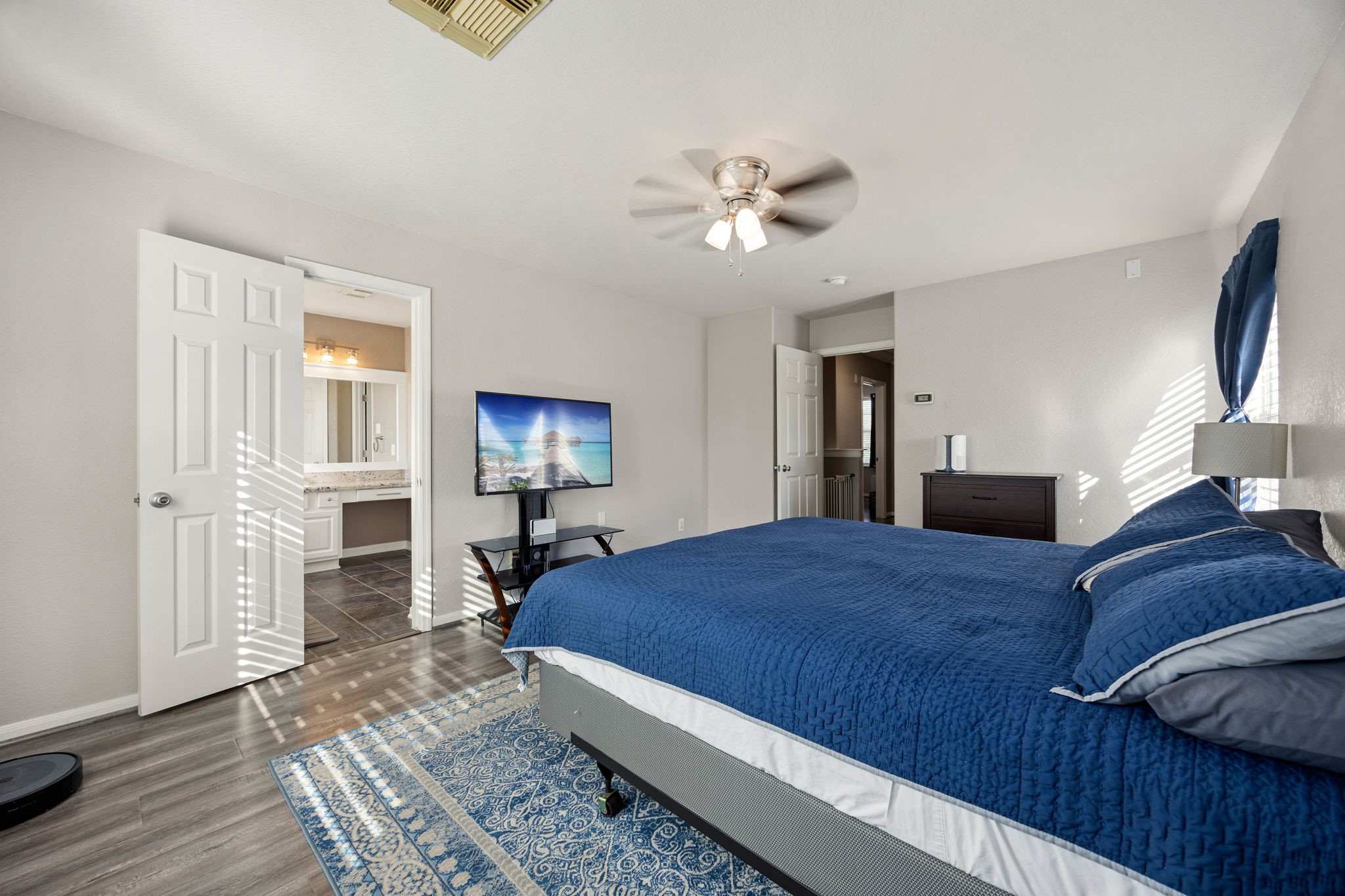 25515 Twister Trail Spring, TX 77373 - Photo 19 of 33 This spacious bedroom features modern flooring, a ceiling fan, and ample natural light. It includes an en-suite bathroom.