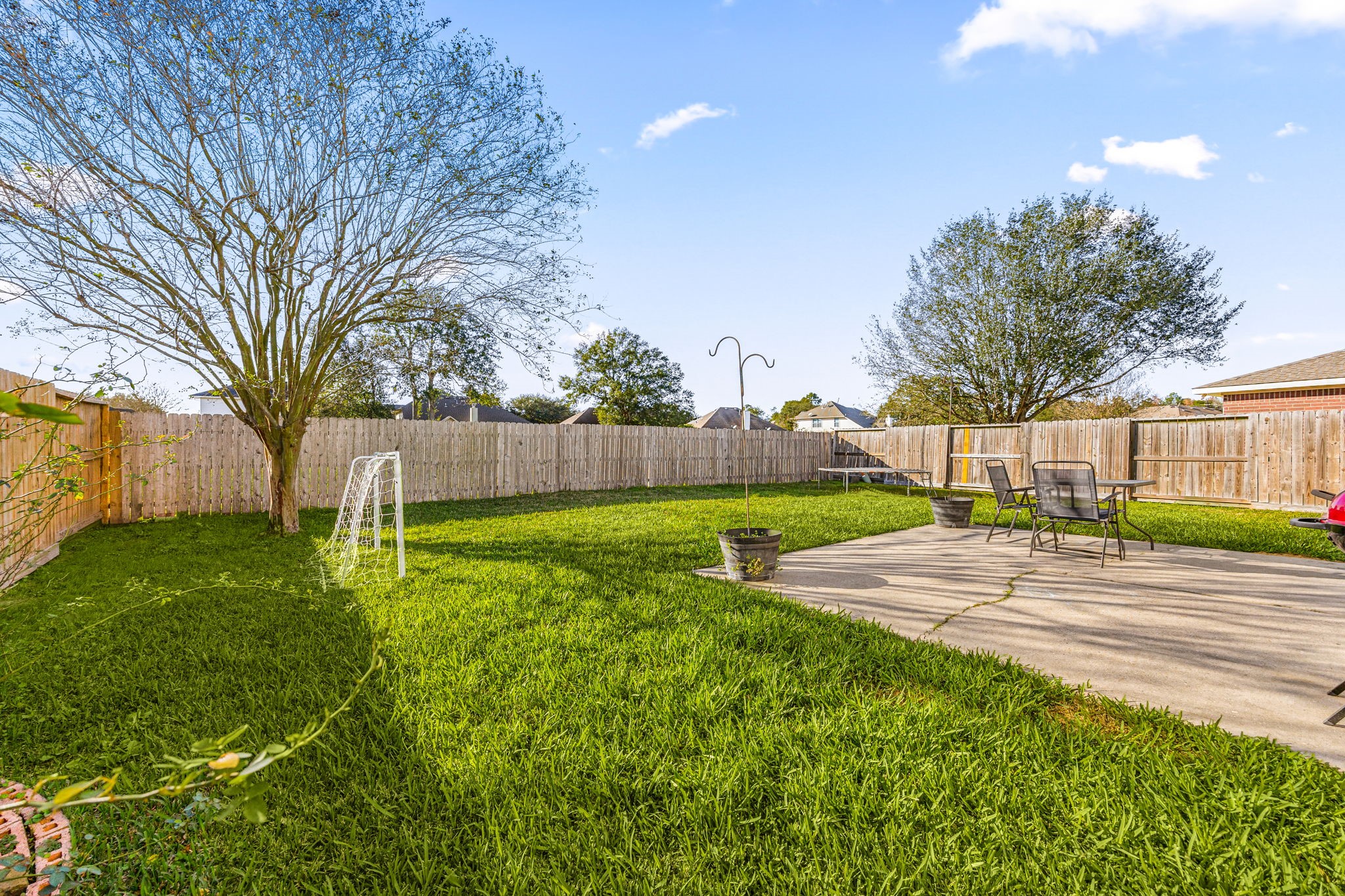 25515 Twister Trail Spring, TX 77373 - Photo 27 of 33 Spacious backyard with lush grass, a small soccer goal, and mature trees. There's a concrete patio with outdoor seating, perfect for relaxation or entertaining.