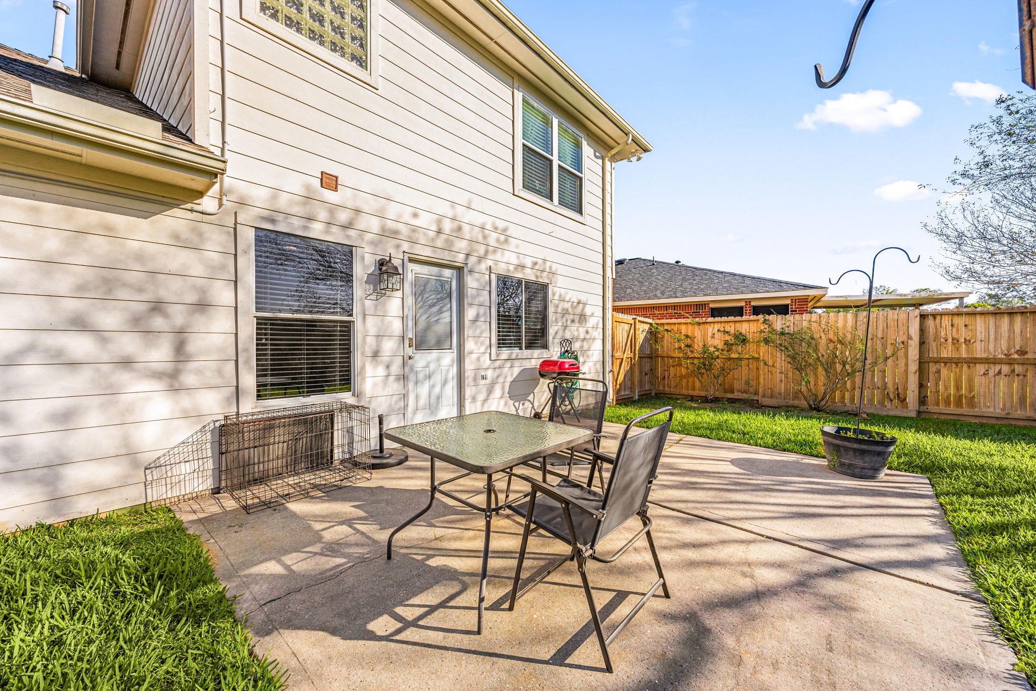 25515 Twister Trail Spring, TX 77373 - Photo 29 of 33 Charming backyard patio with a concrete surface, ideal for outdoor dining and relaxation. Features a table and chairs, surrounded by a fenced grassy area, perfect for privacy and enjoying the outdoors.