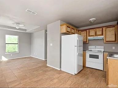 1426 East Rogers Road, Unit 47 Edinburg, TX 78542 - Photo 13 of 13 Kitchen with white appliances, under cabinet range hood, brown cabinetry, a sink, and open floor plan