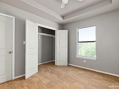 1426 East Rogers Road, Unit 47 Edinburg, TX 78542 - Photo 10 of 13 Unfurnished bedroom with a raised ceiling, baseboards, a closet, and a ceiling fan