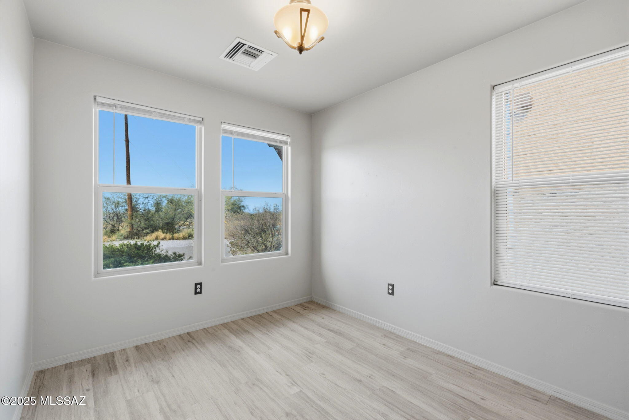 1458 North Wentworth Road Vail, AZ 85641 - Photo 9 of 44 a view of an empty room with wooden floor and a window