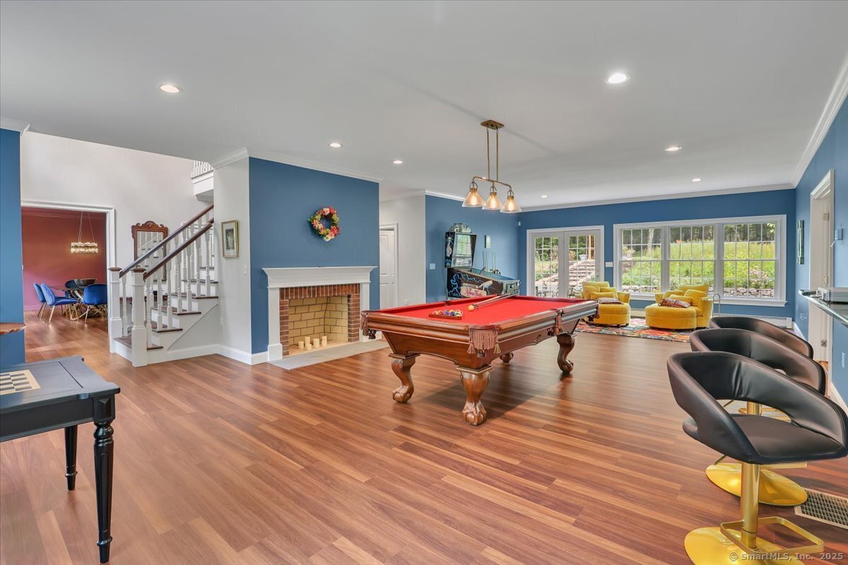 152 Cheney Lane Coventry, CT 06238 - Photo 18 of 49 The front to back game room on the main level is complete with a wood burning fireplace and pool table. Large windows and atrium door add light to this room. Atrium door leads to back yard.