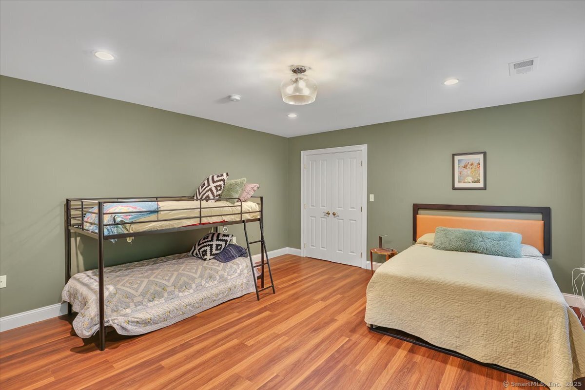 152 Cheney Lane Coventry, CT 06238 - Photo 21 of 39 a bedroom with a bed and a chandelier