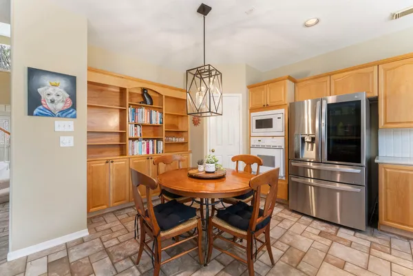 a kitchen with stainless steel appliances granite countertop a dining table and chairs