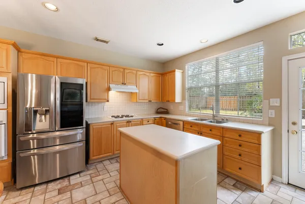 a kitchen with stainless steel appliances granite countertop a refrigerator sink and stove