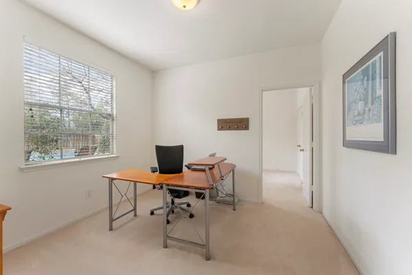 a view of a workspace with furniture and a window