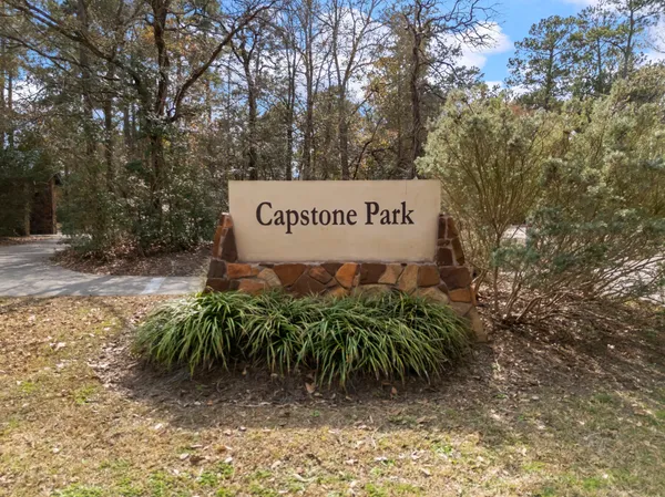 a sign that is sitting in front of a tree