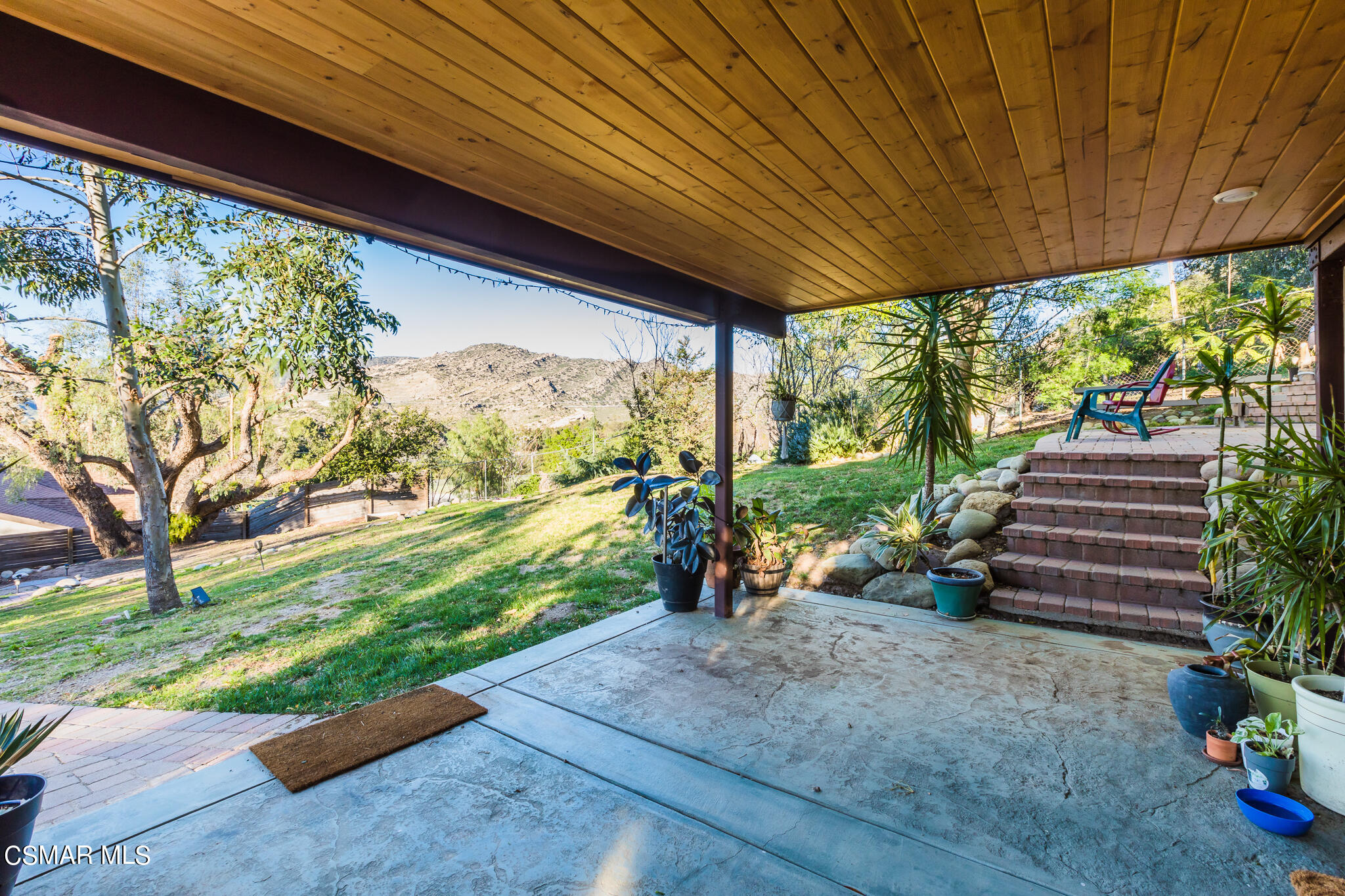 6695 Clear Springs Road Simi Valley, CA 93063 - Photo 12 of 94 a view of a patio with lawn chairs next to a yard