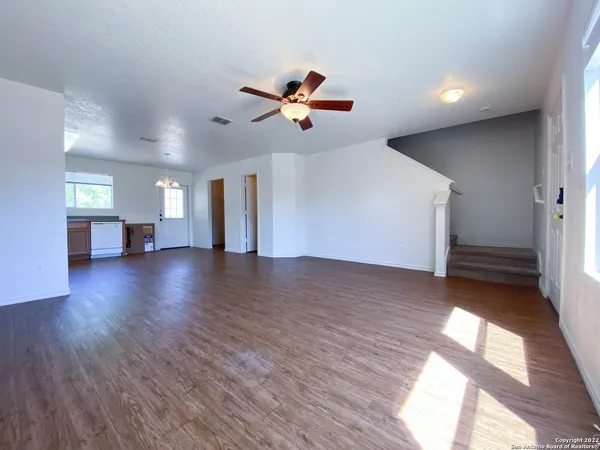a view of a livingroom with wooden floor and a ceiling fan