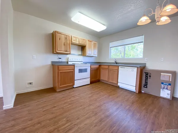 a view of kitchen with stainless steel appliances granite countertop a stove and a wooden floors