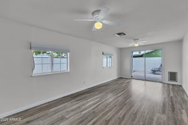 a view of empty room with wooden floor and window
