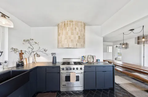 a kitchen with stainless steel appliances a sink a stove and a window