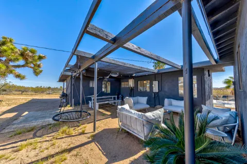 a view of a backyard with swimming pool and sitting area