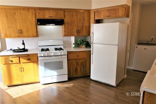 214 South Fire Opal Street Ridgecrest, CA 93555 - Photo 7 of 29 a kitchen with a stove a refrigerator and a sink