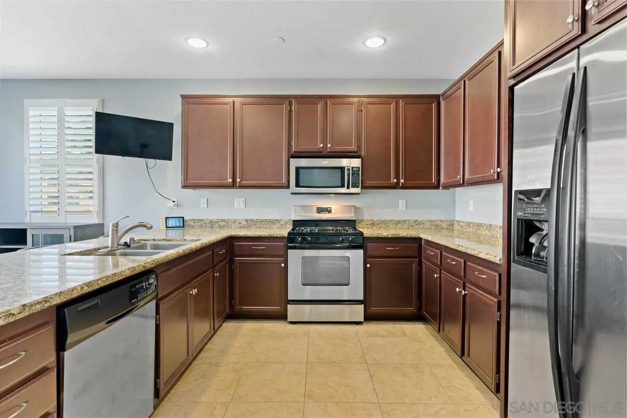 9811 Old Tree Lane Santee, CA 92071 - Photo 11 of 45 a kitchen with stainless steel appliances granite countertop a refrigerator stove top oven a sink and dishwasher
