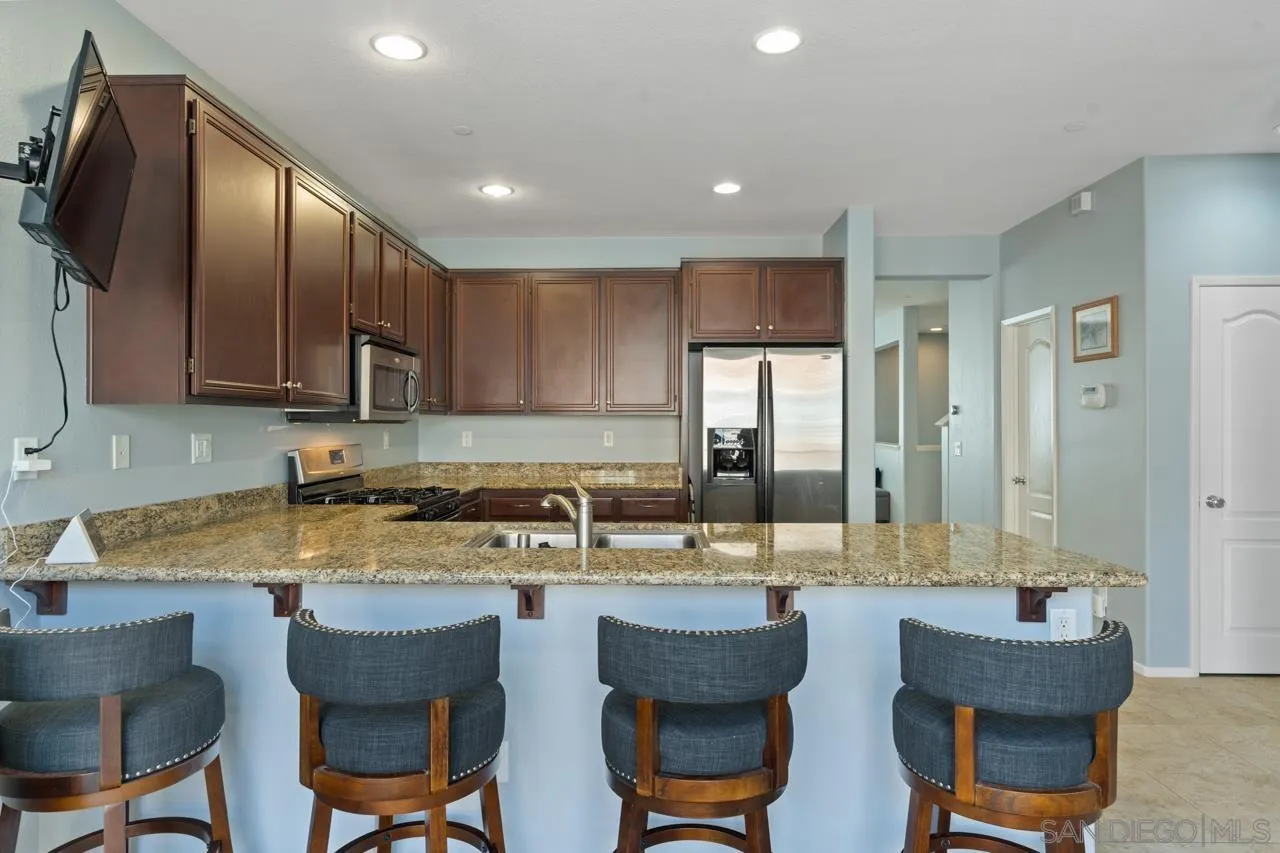 9811 Old Tree Lane Santee, CA 92071 - Photo 16 of 45 a kitchen with a dining table chairs and refrigerator