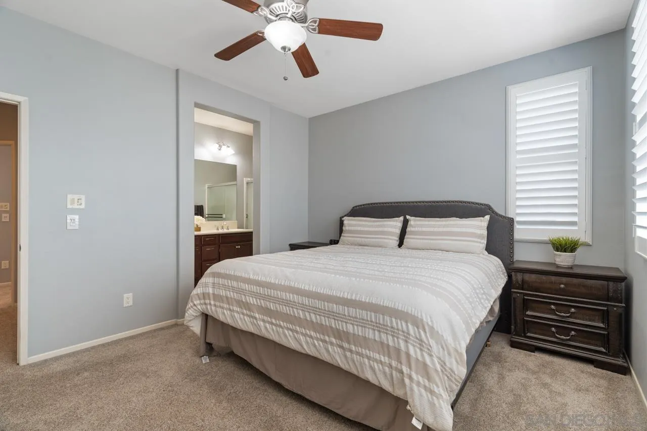 9811 Old Tree Lane Santee, CA 92071 - Photo 22 of 45 a bedroom with a bed and a chandelier