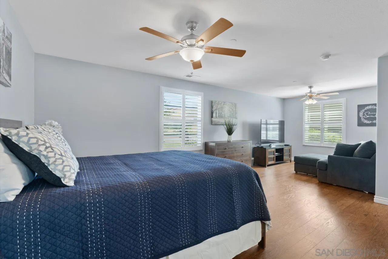 9811 Old Tree Lane Santee, CA 92071 - Photo 29 of 45 a spacious bedroom with a bed a couch and a large window