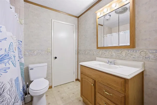a bathroom with a sink toilet and mirror