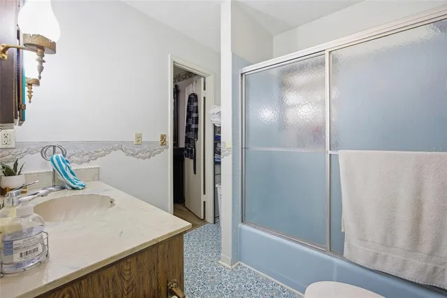a view of a room with wooden floor chandelier and windows