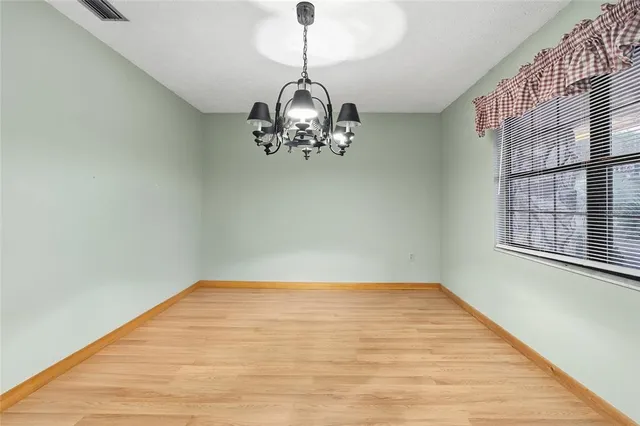 a view of a livingroom with a chandelier fan and wooden floor
