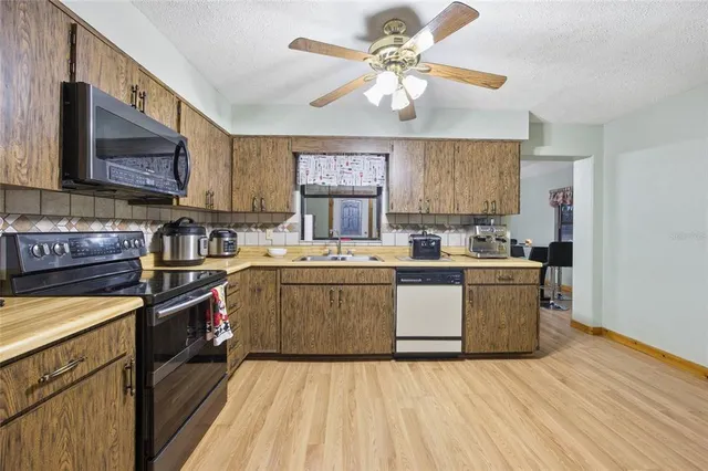 a large kitchen with a refrigerator and a sink