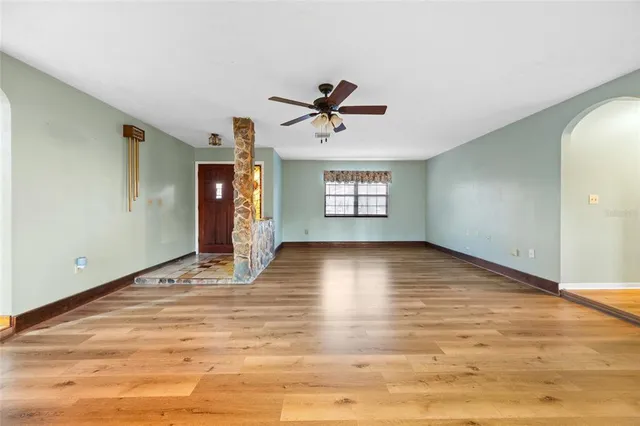 a view of an empty room with window and wooden floor
