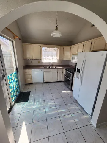 a kitchen with stainless steel appliances granite countertop a sink a stove a refrigerator and cabinets