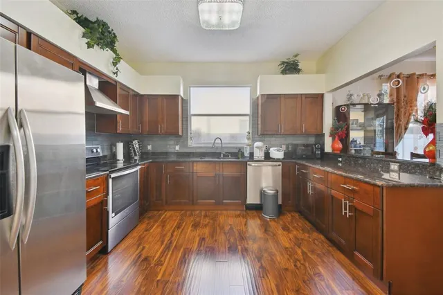 a kitchen with granite countertop a stove and a refrigerator