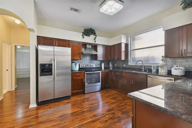 a kitchen with stainless steel appliances granite countertop a sink stove and cabinets