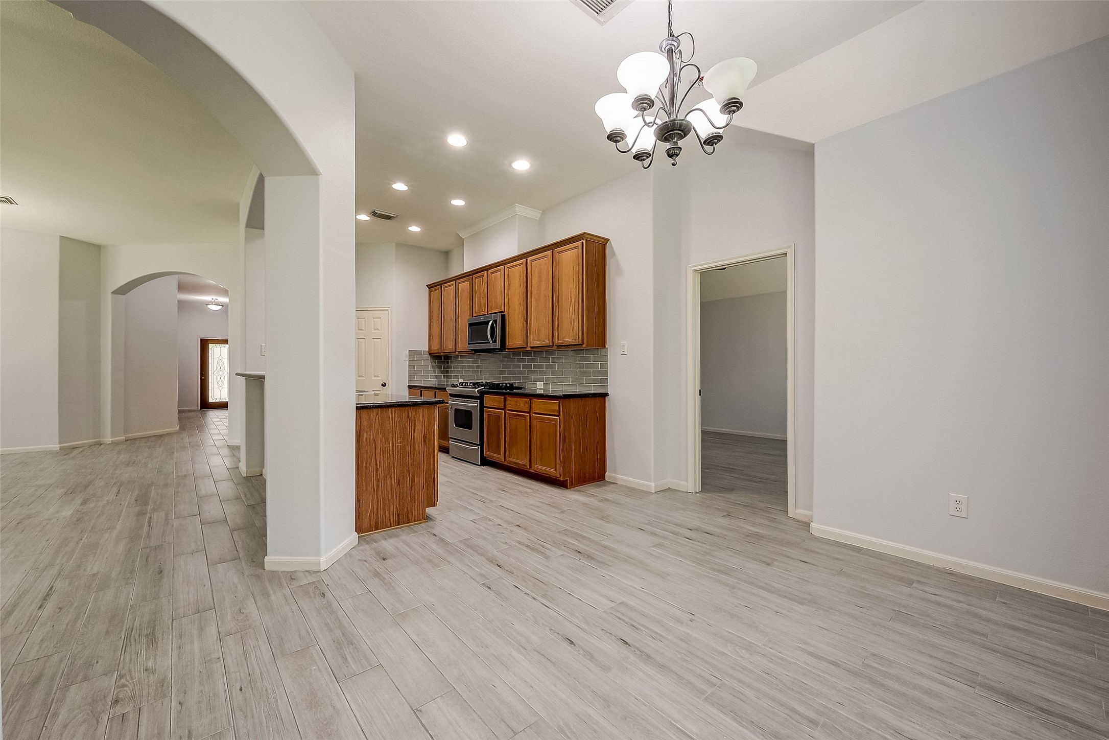 18302 North Elizabeth Shore Loop Cypress, TX 77433 - Photo 12 of 41 a kitchen with stainless steel appliances a chandelier and wooden floor