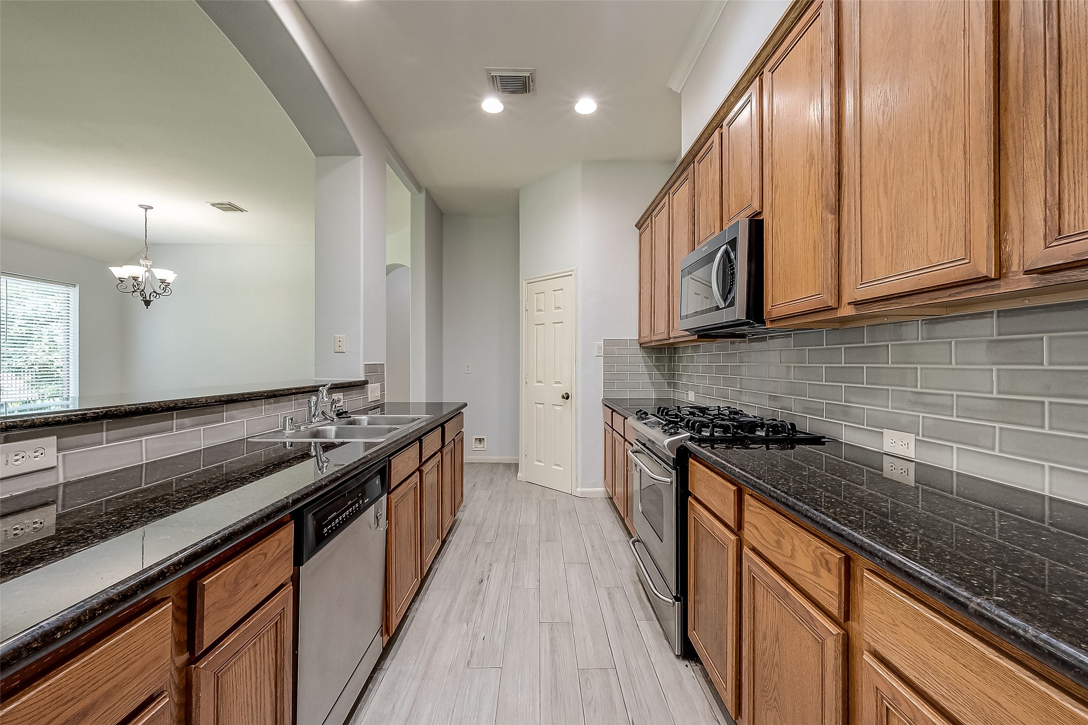 18302 North Elizabeth Shore Loop Cypress, TX 77433 - Photo 15 of 41 a kitchen with granite countertop stainless steel appliances and wooden cabinets