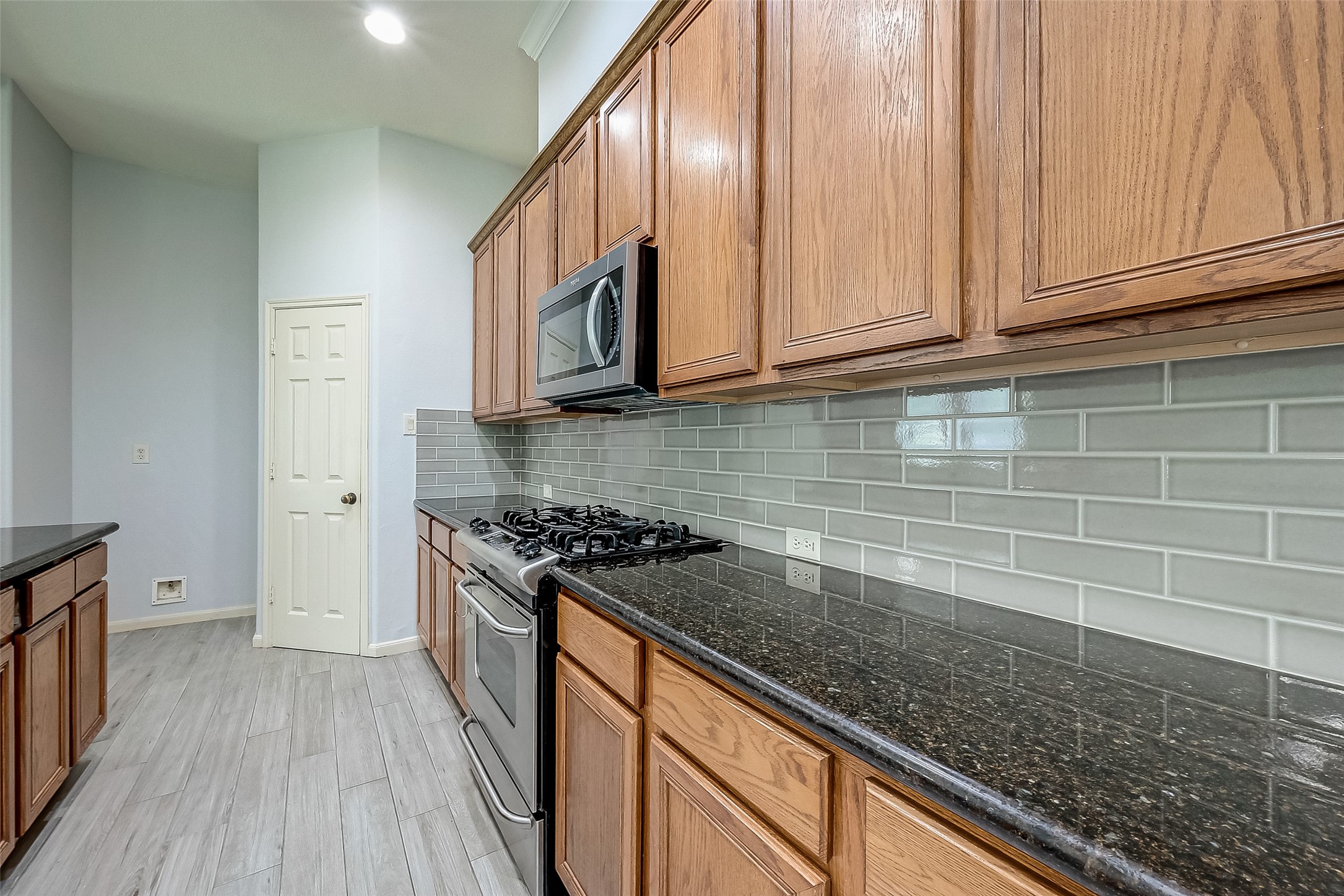 18302 North Elizabeth Shore Loop Cypress, TX 77433 - Photo 16 of 41 a kitchen with stainless steel appliances granite countertop a stove a sink and a microwave