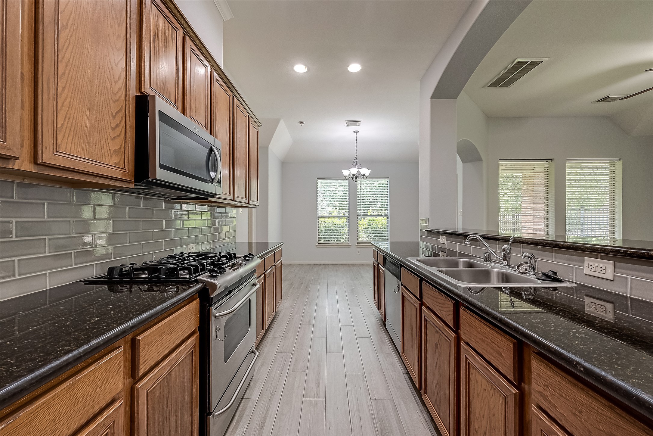 18302 North Elizabeth Shore Loop Cypress, TX 77433 - Photo 20 of 41 a kitchen with stainless steel appliances a sink stove and cabinets
