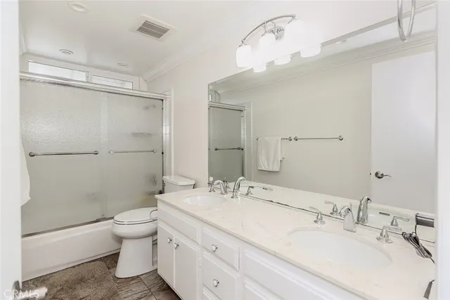 a bathroom with a granite countertop sink mirror vanity and toilet